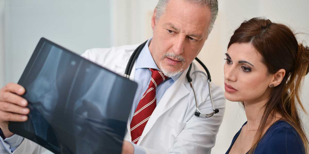 Doctor and Patient are Looking at X - Ray Image